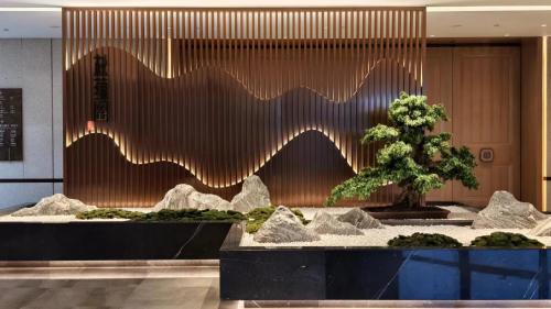 a lobby with a fountain with a tree in front of it at Dongguan DongCheng International Hotel - Free shuttle buses for executive room guests during Canton Fair in Dongguan
