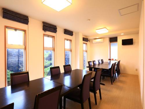a conference room with tables and chairs and windows at Tojinbo Mikuni Onsen Ootoku in Sakai