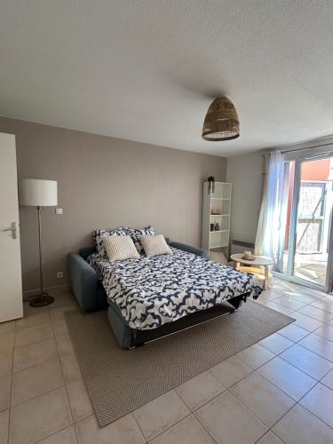 une chambre avec un lit et un canapé bleu dans l'établissement Fleur de Soleil, à Arles