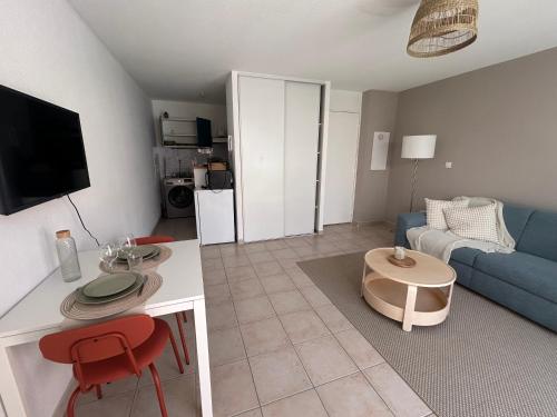 un salon avec un canapé bleu et une table dans l'établissement Fleur de Soleil, à Arles