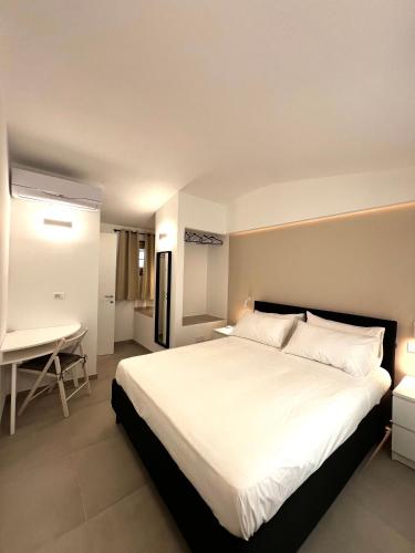 a bedroom with a large white bed and a desk at Casa Camilla in Riomaggiore