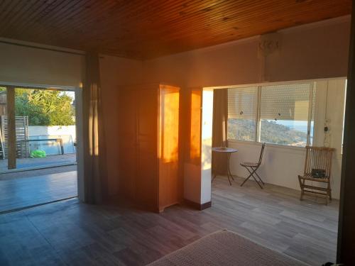 an empty living room with a view of a porch at La Coccinelle in Île du Levant
