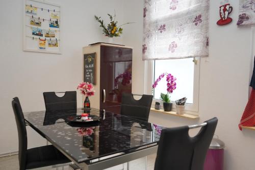 a dining room with a table and chairs and a window at Küstenliebe Cuxhaven 1 in Cuxhaven