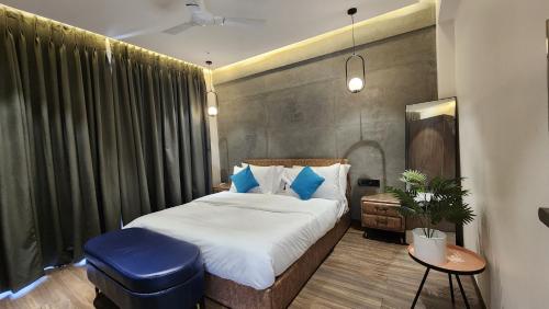 a bedroom with a large bed and a blue stool at Dolce Villa IGATPURI in Igatpuri