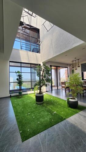 a large room with a green lawn and potted trees at Dolce Villa IGATPURI in Igatpuri