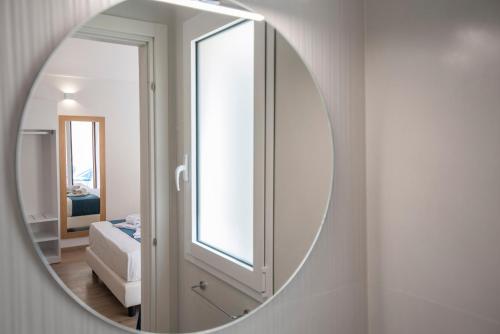 a mirror hanging on a wall in a bedroom at Room 86 in San Vito lo Capo