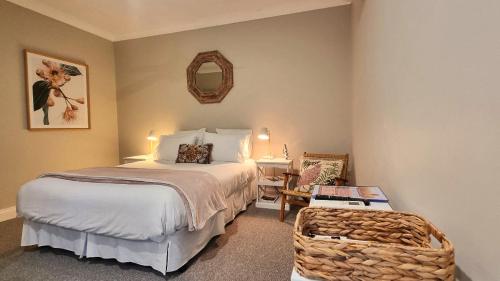 a bedroom with a bed and a chair and a mirror at Fechner Place Barossa, 1 Bed, Wine & Platter in Tanunda