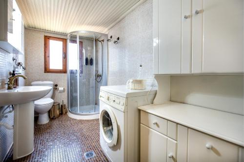 a bathroom with a washing machine and a sink at Etherio House in Skala Sotiros