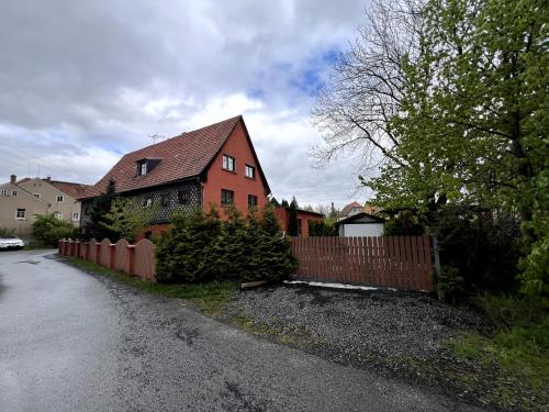 a red house with a fence in front of it at Haus mit Pool Großschönau in Großschönau