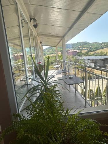 a porch with a table and chairs on a balcony at Hotel Tatul in Momchilgrad