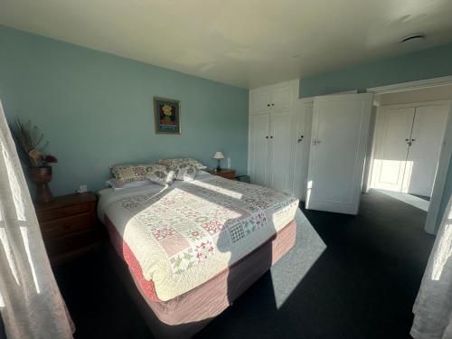 a bedroom with a bed with a quilt on it at Sunny House with 5 Bedrooms(near airport) in Christchurch
