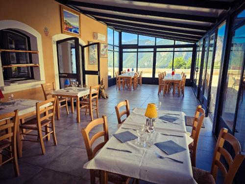 une salle à manger avec tables, chaises et fenêtres dans l'établissement La Gruppio, à Ilonse