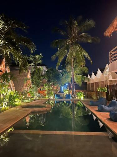 a resort swimming pool at night with palm trees at Living Trawangan Hotel in Gili Trawangan