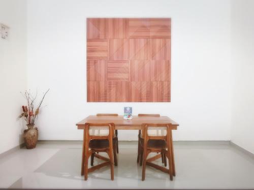 a wooden table with two chairs in a room at Kumpul Kumpul Villa Seminyak - CHSE Certified in Seminyak