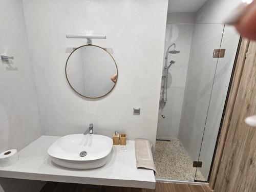 a white bathroom with a sink and a shower at Cute Corner in Khalkoútsion