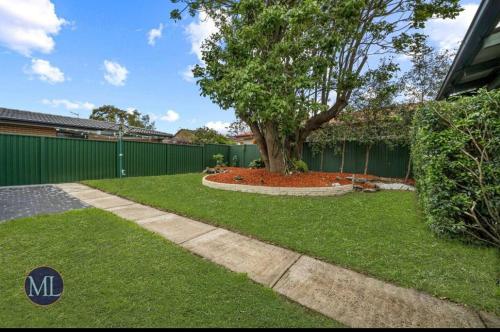 a yard with a tree and a fence at Kirkwood in Castle Hill