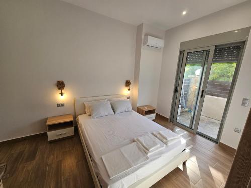 a bedroom with a bed and a large window at Cute Corner in Khalkoútsion