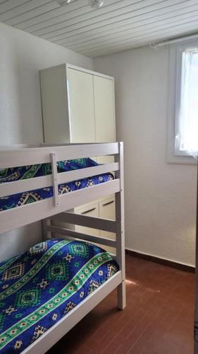 une chambre avec trois lits superposés dans une pièce dans l'établissement Appartement proche mer, au Barcarès