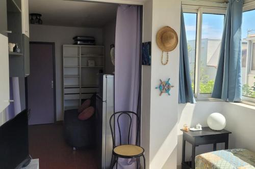 Cette chambre comprend un réfrigérateur, une table et une chaise. dans l'établissement Appartement proche mer, au Barcarès