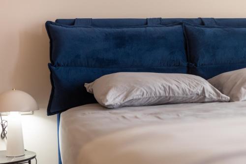 a bed with a blue headboard and a pillow at Zafirakis Suites Amaliada in Amaliás