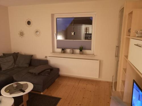 Una sala de estar con un sofá y una ventana. en Ferienhaus Möller, en Waldeck