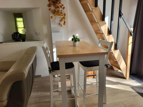 une table et des chaises dans une pièce avec un escalier dans l'établissement Petite Maison - Penty le Ty Couz, à Le Trévoux