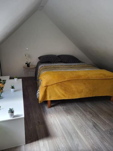 - une chambre mansardée avec un lit jaune dans l'établissement Petite Maison - Penty le Ty Couz, à Le Trévoux