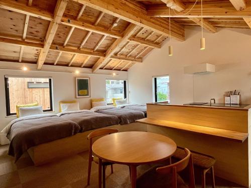 a living room with four beds and a table at ESPLANADE VILLAGE HOTEL b in Kamakura