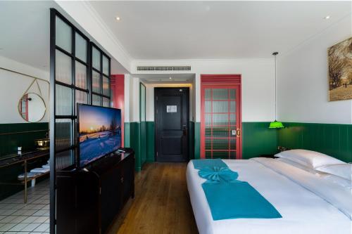 a bedroom with a large bed and a flat screen tv at Hangzhou Lanshe hotel in Hangzhou