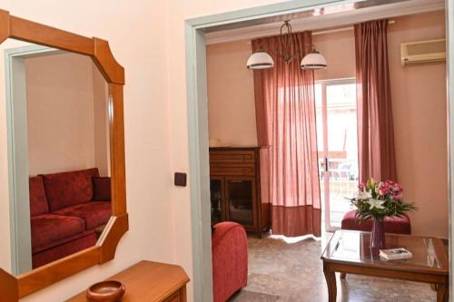 a living room with a red couch and a mirror at Appartement entier in Paralia Katerinis