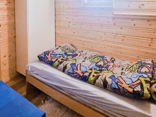 a bed in a room with a wooden wall at 6 person holiday home in Flatanger in Lauvsnes
