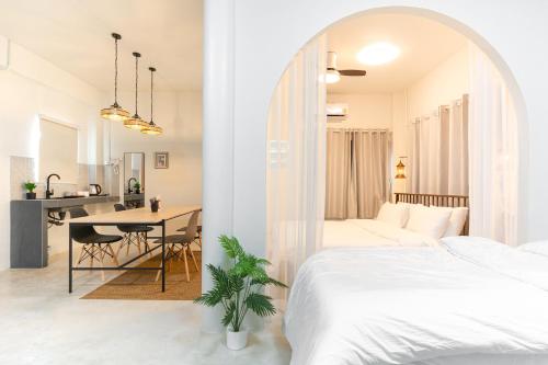a bedroom with a bed and a dining room with a table at Baan Old Town Boutique Stay, Phuket Town in Phuket