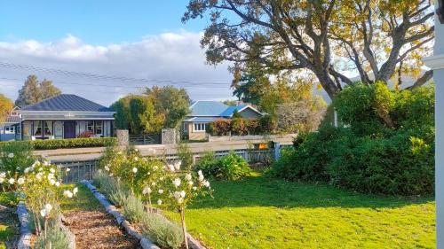 a yard with a fence and some houses at The Oaks- a beautifully appointed 1890s villa in Featherston