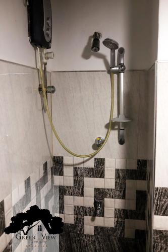 a shower with a hose in a bathroom at Green View in Dambulla