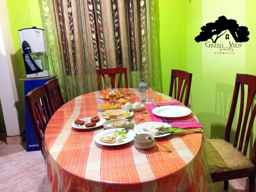 a table with plates of food on top of it at Green View in Dambulla