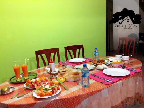 a table with plates of food and drinks on it at Green View in Dambulla