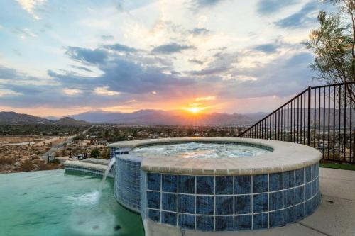 a hot tub with a sunset in the background at Sunset House Joshua Tree Infinity Pool Spa Views Hiking Trail in Yucca Valley
