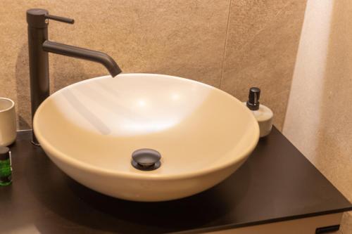 a white sink on a black counter in a bathroom at Zafirakis Suites Amaliada in Amaliás