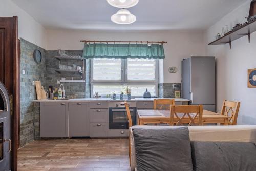 a kitchen with a table and a dining room at Chalupa Ema Nikol in Rovensko pod Troskami
