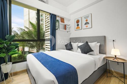 a bedroom with a large bed and a large window at Belia by Kozystay - BSD in Tangerang