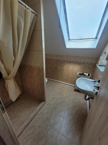 a bathroom with a sink and a shower with a window at AZTA central Apartments in Hévíz