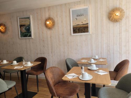 a dining room with wooden tables and chairs at Brit Hotel des Halles in Concarneau