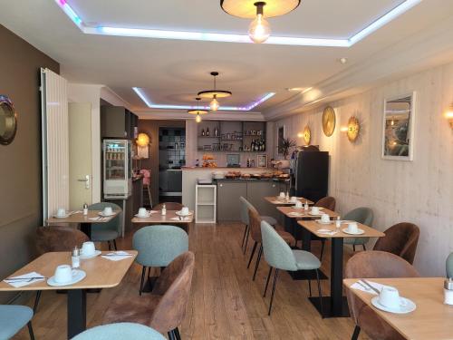 un restaurant avec des tables et des chaises en bois et une cuisine dans l'établissement Brit Hotel des Halles, à Concarneau