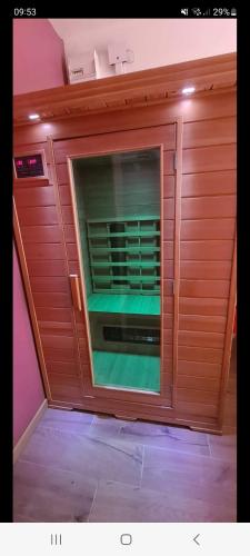 a room with a wooden wall with a microwave oven at Maison avec piscine chauffée, jacuzzi et sauna 6 chambres in Saint-Paul