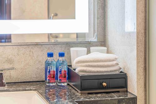 a bathroom counter with two bottles of water and towels at Zhaolin Grand Hotel in Beijing