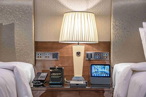 a lamp on a table in a hotel room with two beds at Zhaolin Grand Hotel in Beijing