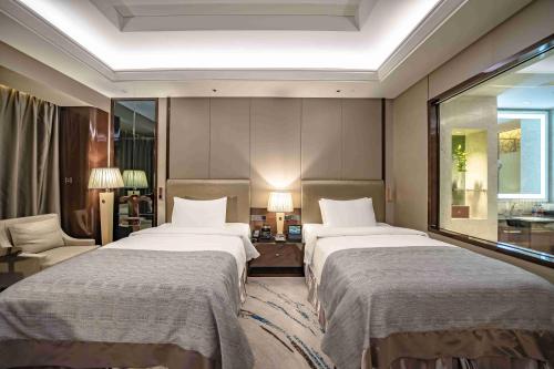a hotel room with two beds and a window at Zhaolin Grand Hotel in Beijing