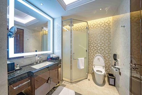 a bathroom with a shower and a toilet and a sink at Zhaolin Grand Hotel in Beijing