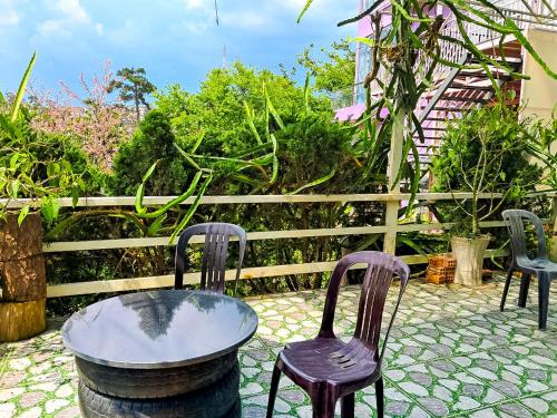 two chairs and a table on a patio at Robins Guesthouse in Da Lat