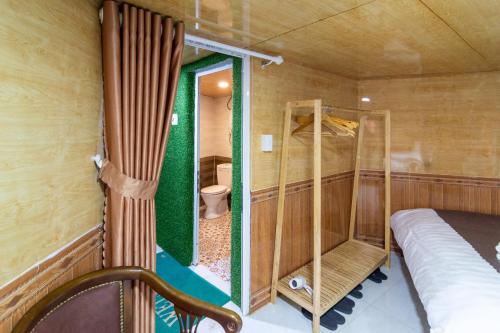 a small room with a bed and a toilet at Robins Guesthouse in Da Lat